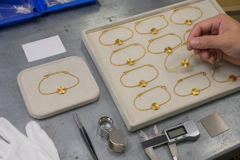 Approved jewelry sample compared with bulk production pieces for consistency checking
