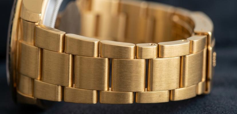 Photo macro d'un bracelet de montre en acier inoxydable revêtu de PVD doré, montrant sa couleur uniforme et dense.