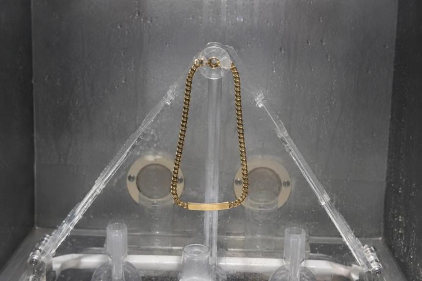 Cleaning gold stainless steel jewelry with soft cloth to preserve shine and finish