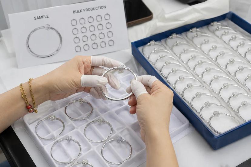 Approved jewelry sample compared with matching bulk production pieces for quality consistency