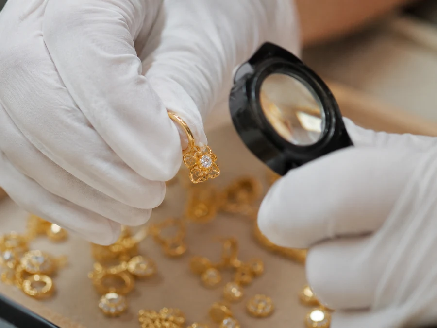 Inspección de calidad de joyería con guantes y lupa antes del envío. Inspección de calidad de joyería con guantes y lupa antes del envío.